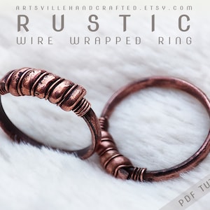 May include: Two copper wire wrapped rings on a white fuzzy surface. The ring on the left has a thicker wire wrap. The text "RUSTIC WIRE WRAPPED RING" is at the top of the image. The text "PDF TUTORIAL" is at the bottom right of the image.