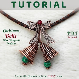 Może przedstawiać: Wisiorek w kształcie dzwonka choinkowego owinięty miedzianym drutem, z czerwoną kokardką i zielonymi akcentami z kamieni szlachetnych. Wisiorek jest na brązowym skórzanym sznurku. Samouczek PDF.