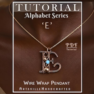 May include: A gold-toned wire-wrapped pendant, shaped like the letter "E", suspended from a fine chain. The pendant incorporates small beads and a turquoise stone. The image includes text: "Tutorial Alphabet Series 'E' Wire Wrap Pendant Artsville Handcrafted".