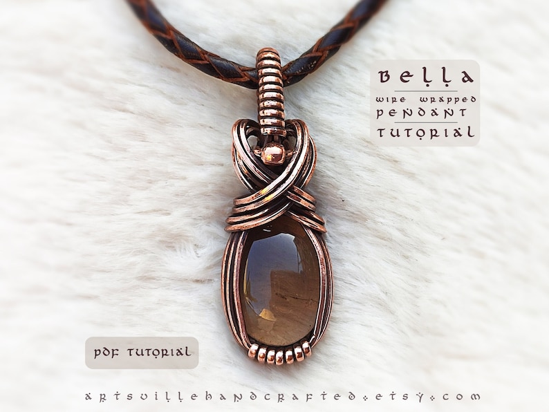 K&ouml;nnte beinhalten: Ein mit Kupferdraht umwickelter Anh&auml;nger mit einem braunen Edelstein. Der Anh&auml;nger h&auml;ngt an einer braunen Lederschnur. Der Text "bella wire wrapped pendant tutorial" ist auf wei&szlig;em Hintergrund geschrieben. Der Text "pdf tutorial" ist unter dem Anh&auml;nger geschrieben. Der Text "artsvillehandcraftedsets.com" ist unter dem Text "pdf tutorial" geschrieben.