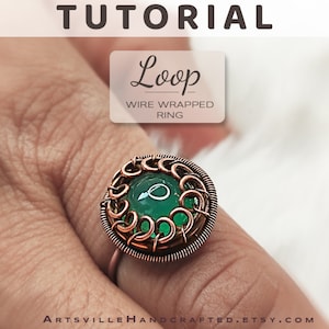 Puede incluir: Un anillo de alambre envuelto en cobre con una piedra preciosa verde. El anillo está en un dedo y el texto "Loop Wire Wrapped Ring" es visible sobre el anillo.