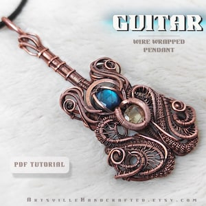 Puede incluir: Colgante de guitarra envuelto en alambre de cobre con piedras preciosas azules y transparentes. El colgante está unido a un cordón negro. El texto "GUITAR WIRE WRAPPED PENDANT" y "PDF TUTORIAL" es visible en la imagen.
