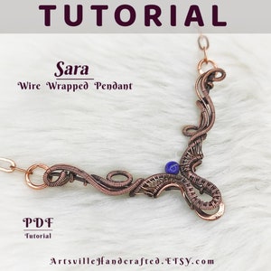 Può includere: Una collana con un ciondolo in filo di rame avvolto e una pietra preziosa blu. Il ciondolo ha la forma di un motivo floreale stilizzato. La collana è su una superficie bianca e pelosa. Il testo "Sara Wire Wrapped Pendant" è sopra il ciondolo. Il testo "PDF Tutorial" è sotto il ciondolo. Il testo "ArtsvilleHandcrafted.Etsy.com" è sotto il testo del tutorial.