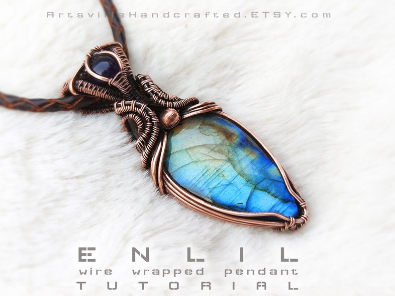 Puede incluir: Un colgante envuelto en alambre de cobre con una piedra preciosa de labradorita azul y verde y una piedra preciosa de amatista m&aacute;s peque&ntilde;a en la parte superior. El colgante cuelga de un cord&oacute;n de cuero marr&oacute;n.