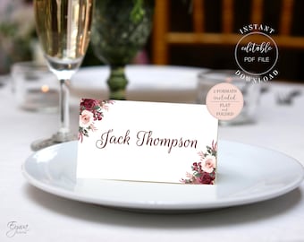 May include: A white place card with a burgundy floral design and the name "Jack Thompson" printed in black script. The place card is on a white plate.