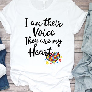 K&ouml;nnte beinhalten: Wei&szlig;es T-Shirt mit dem Text "I am their Voice They are my Heart" und einem Herz aus Puzzle-Teilen in Blau, Rot, Gelb und Gr&uuml;n.
