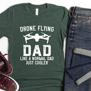 May include: A green t-shirt with the text "Drone Flying Dad Like a Normal Dad Just Cooler" in white. The shirt features a graphic of a drone in white.
