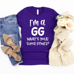 May include: Purple t-shirt with white text that reads "I'm a GG What's your super power?"