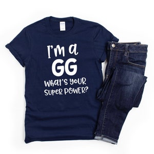 May include: A navy blue t-shirt with white text that reads "I'm a GG What's your super power?"