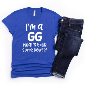 May include: A royal blue t-shirt with white text that reads "I'm a GG What's your super power?"