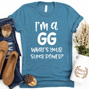 May include: A teal blue t-shirt with white text that reads "I'm a GG What's your super power?"