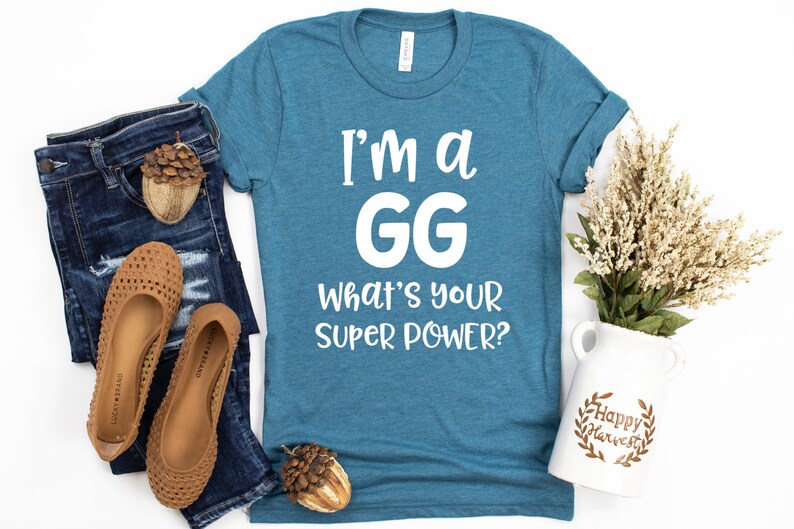 May include: A teal blue t-shirt with white text that reads "I'm a GG What's your super power?"