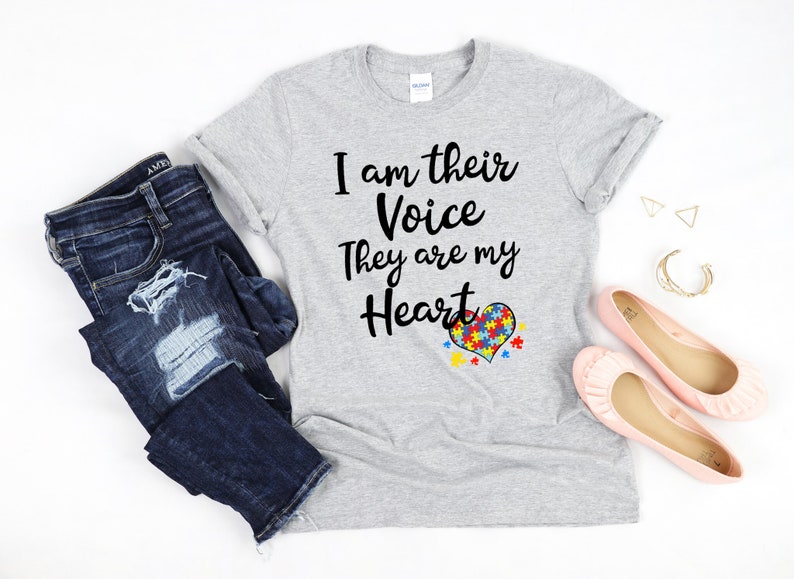 K&ouml;nnte beinhalten: Ein graues T-Shirt mit dem Text "Ich bin ihre Stimme Sie sind mein Herz" und einem herzf&ouml;rmigen Puzzle-St&uuml;ck-Design.