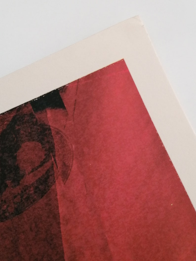 Puede incluir: Un primer plano de una pintura abstracta roja y negra. La pintura tiene una superficie texturizada y parece estar hecha con un pincel.