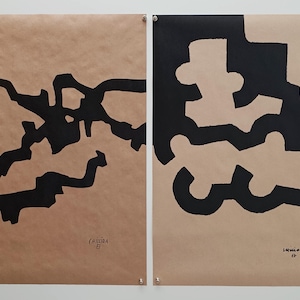 Op de afbeelding: Twee rechthoekige prints op beige papier met gedurfde zwarte abstracte vormen. De linker print toont grillige, vertakte lijnen, terwijl de rechter print dikke, in elkaar grijpende vormen laat zien. Elke print bevat de handtekening Chillida in de hoek.