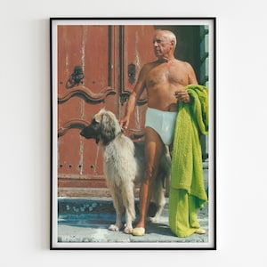 Op de afbeelding: Een man in witte onderbroek en een groene handdoek staat met een hond voor een houten deur.