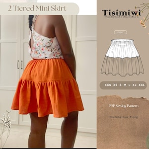 Puede incluir: Se muestra una minifalda naranja de dos niveles. La falda se combina con una blusa con estampado floral. La imagen también incluye un boceto de la falda, opciones de tallas y el texto "2 Tiered Mini Skirt", "Tisimiwi", "PDF Sewing Pattern" y "Youtube Sew Along".