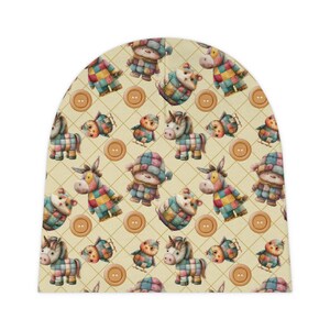 Peut inclure: Un bonnet beige avec un motif r&eacute;p&eacute;t&eacute; d'animaux en patchwork et de boutons. Les animaux comprennent une licorne, un &acirc;ne, un ours et un oiseau. Les boutons sont bruns et ont deux trous.
