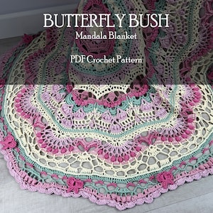 Op de afbeelding: Een haakmandaladekenpatroon genaamd "Butterfly Bush" in een crème, roze en groene kleurstelling. Het patroon is beschikbaar als PDF-download.
