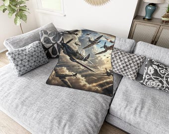 Puede incluir: Una manta gris y blanca con una imagen vintage de aviones de combate volando en formación contra un cielo nublado.