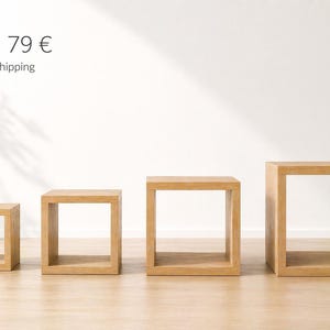 Puede incluir: Cuatro mesas auxiliares cuadradas de madera de diferentes tamaños. Las mesas son de madera de color claro y tienen un diseño abierto en forma de caja. Las mesas están dispuestas en fila, la más pequeña a la izquierda y la más grande a la derecha.