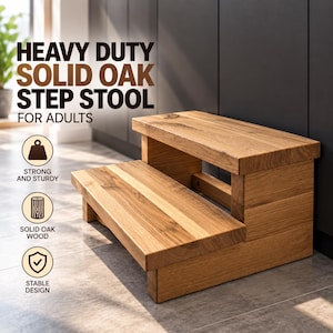 Könnte beinhalten: Ein zweistufiger Hocker aus massivem Eichenholz mit einer natürlichen hellbraunen Maserung. Der Text HEAVY DUTY SOLID OAK STEP STOOL FOR ADULTS ist sichtbar, zusammen mit Symbolen für STRONG AND STURDY, SOLID OAK WOOD und STABLE DESIGN.
