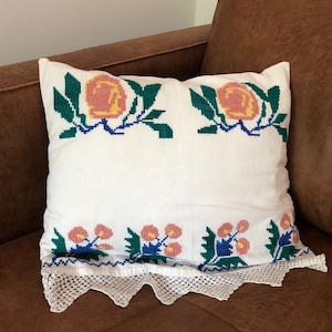 Traditional Romanian pillow case with cross stitched floral design and lace