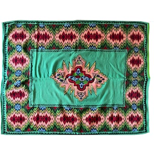 Romanian flatwoven rug geometrical design on a green turquoise background