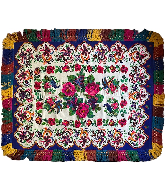 Gorgeous floral carpet with blue and pink beautiful flowers on a white background and colourful fringes