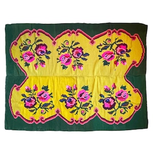 Vintage wool rug with pink flowers on green and yellow background made by hand in Transylvania