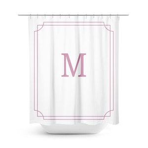 May include: White shower curtain with a pink letter M in a decorative frame.