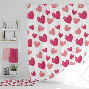 May include: A white shower curtain with a pink and red watercolor heart pattern. The hearts are of varying sizes and are scattered randomly across the curtain.