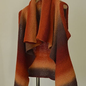 Peut inclure: Un cardigan en tricot sans manches avec un d&eacute;grad&eacute; de couleurs orange, marron et bordeaux. Le cardigan a un col drap&eacute; et une coupe ample.