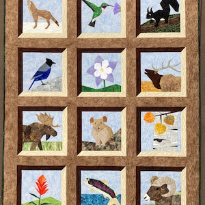 May include: A handmade quilt featuring 12 framed blocks with Rocky Mountain wildlife and flora. Each block showcases a different animal or plant, including a wolf, hummingbird, and flower. The quilt is bordered with a brown fabric and includes the text "Life in the Rocky Mountains".