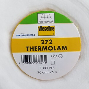 Könnte beinhalten: Ein gelbes und grünes Etikett mit dem Text "vlieseline" und "THERMOLAM" darauf. Das Etikett hat auch einen Barcode, ein Waschanleitungssymbol und den Text "272", "100% PES", "90 cm x 25 m".
