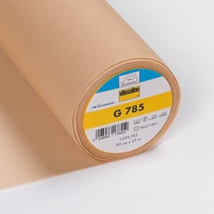 May include: A roll of beige Vlieseline G 785 interfacing fabric. The label reads "Vlieseline G 785 100% PES 90 cm x 25 m".