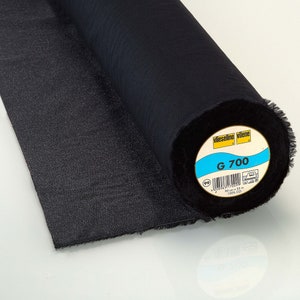 May include: A black roll of Vlieseline Vilene G 700 interfacing fabric. The label is blue and yellow and says "Vlieseline Vilene G 700 90 cm x 25 m 100% CO".