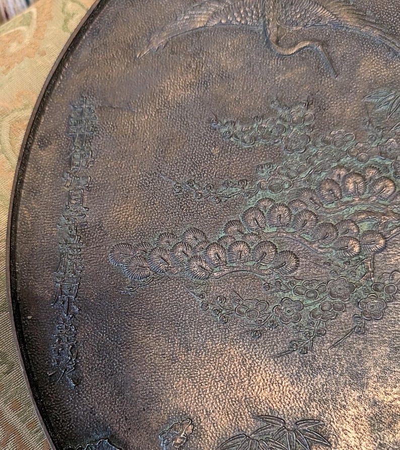 Antique Japanese Kagami - Bronze Antique Hand Mirror - Flying Cranes Turtle, Pine Trees, Pond Theme Meiji or Taishō Period 1868-1926
This piece roughly from the Meiji period (1868-1921) or Taisho period (1921-1926) is a Japanese bronze