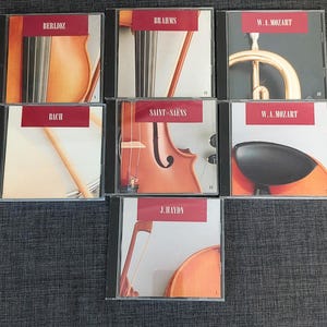 Può includere: Un set di sei dischi compatti con compositori classici, tra cui Berlioz, Brahms, Bach, Saint-Saëns, W.A. Mozart e J. Haydn. Ogni disco ha un'immagine diversa sul davanti, tra cui un violino, una tromba e un violoncello.