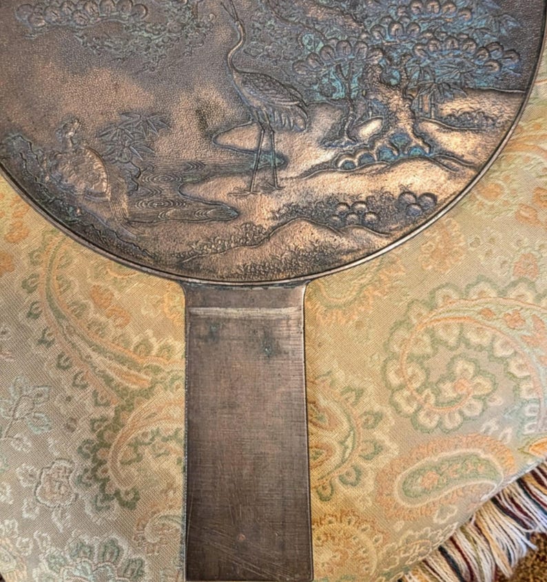 Antique Japanese Kagami - Bronze Antique Hand Mirror - Flying Cranes Turtle, Pine Trees, Pond Theme Meiji or Taishō Period 1868-1926
This piece roughly from the Meiji period (1868-1921) or Taisho period (1921-1926) is a Japanese bronze