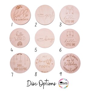 May include: Nine wooden discs with various engraved designs for baby milestones. The designs include "hello I'm new here", "It's a girl", "hello little one", "hello world", "It's a boy", "hello little one", "SHHH... baby sleeping", "My first tooth", and "My 1st birthday".