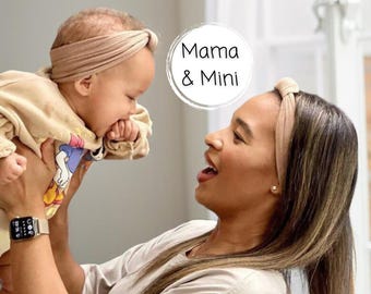 May include: A woman and baby wearing matching beige headbands. The baby is being held up by the woman. The image has the text "Mama & Mini" in a white circle. The baby is wearing a beige outfit.