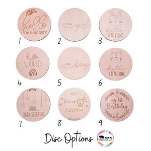 Puede incluir: Nueve discos de madera con grabados, incluyendo frases como "Hello, I'm new here", "It's a girl" y "My first tooth". Estos discos est&aacute;n dise&ntilde;ados para marcar los hitos del beb&eacute; y son de madera clara.