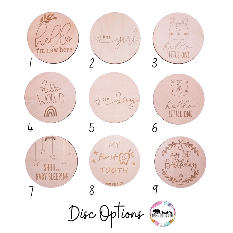 May include: Nine wooden discs with various engraved designs for baby milestones. The designs include "hello I'm new here", "It's a girl", "hello little one", "hello world", "It's a boy", "hello little one", "SHHH... baby sleeping", "My first tooth", and "My 1st birthday".