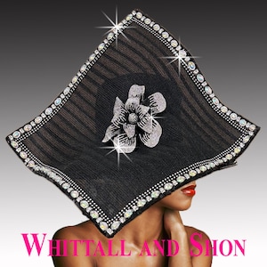 May include: A black, square-shaped hat with a silver flower and rhinestone trim. The hat has a ribbed texture and is embellished with sparkling rhinestones around the edges. The text "Whittall and Shon" is at the bottom.