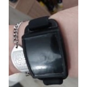 Close up view of a black nvs magnet with a black silicone band on an adult wrist.