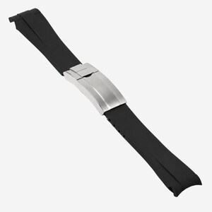 Puede incluir: Una correa de reloj de goma negra con un cierre de acero inoxidable. La correa est&aacute; en &aacute;ngulo diagonalmente sobre un fondo blanco. El cierre es de color plata cepillada.