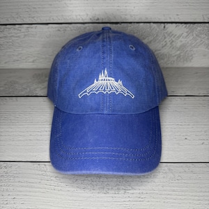 May include: A royal blue baseball cap with a white embroidered design of the Spaceship Earth attraction at Epcot.