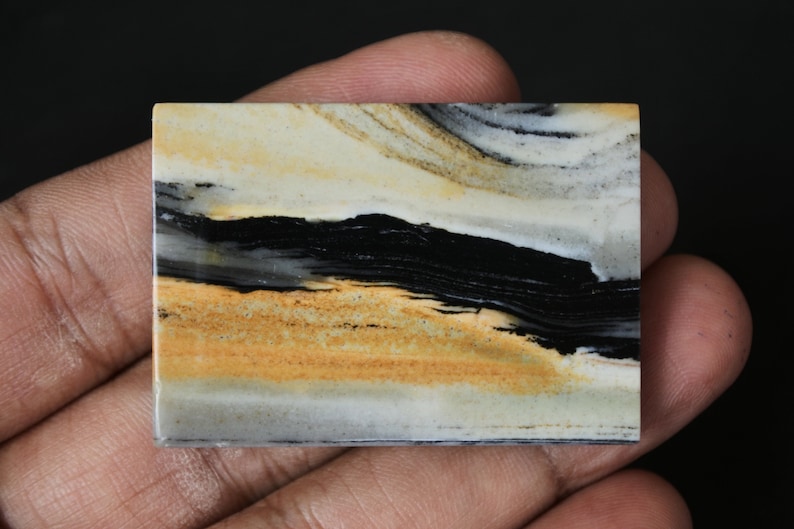 May include: A rectangular slab of banded agate with black, white, and yellow stripes. The agate has a polished surface and is a natural stone.