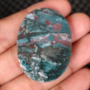 Pode incluir: Caboch&atilde;o oval de &aacute;gata verde, azul e marrom com um padr&atilde;o de redemoinho.